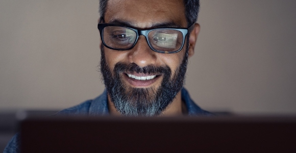 Man in front of computer wearing glasses